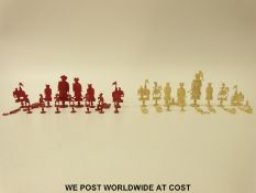 A 19thC Chinese carved ivory chess set, one side stained in red,