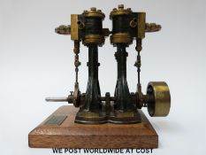 A twin cylinder marine steam engine mounted on a wooden base with plaque for Stevens Model Dockyard,