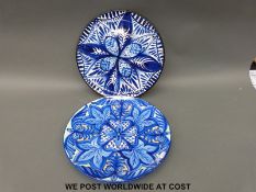 A pair of decorative blue and white Spanish chargers.
