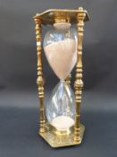 A giant brass and glass one hour egg timer with zodiac decoration,