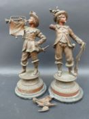 A pair of spelter figures one with a bid and a gun, the other with a trumpet and sword,