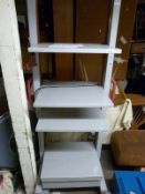 An adjustable height shelf unit on wheels