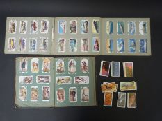 Three cigarette card albums containing largely transport related subjects including trains,