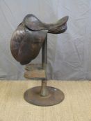 A leather saddle bar stool on industrial steel base