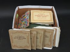 A quantity of world stamps in albums and a quantity of cigarette card albums