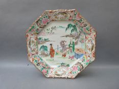 A Chinese octagonal charger decorated with three figures holding a scroll painting,