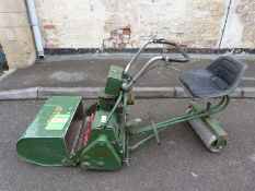 An Atco sit on petrol mower with manual