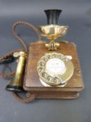 A reproduction brass wall mounted telephone in the style of a GPO 121