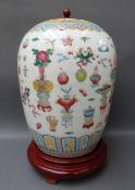 A Chinese ginger jar decorated in the 100 antiques pattern on turned wooden base, with matching lid,