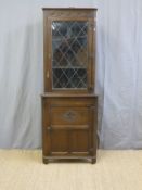 An oak double height corner cupboard,