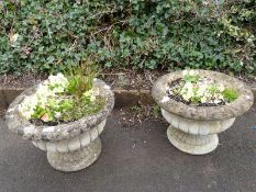 A pair of reconstituted stone urns.