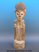 An African tribal figure of a man crouching with rope hair,
