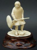 A 19thC carved ivory figure of a Japanese workman on wooden plinth,