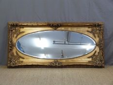 A large gilt framed oval bevelled edge mirror,