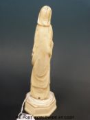 A Japanese Meiji period carved ivory okimono of a flower seller with a stick,