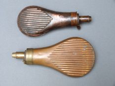 Two copper and brass powder flasks both with embossed reeded decoration, largest 18cm long.