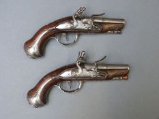A pair of French flintlock hammer action pocket pistols with ornately carved stocks decorated with