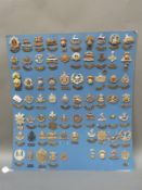A carded display of the British army cap badges and shoulder titles featuring the sixty regiments