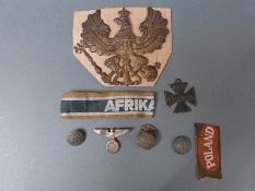 A collection of WWI and WWII German insignia including helmet badge