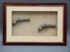 A pair of decorative flintlock hammer action pistols in glass display case