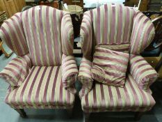 A pair of reproduction wing back armchairs with striped upholstery