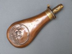 James Dixon & Sons copper and brass powder flask with embossed decoration of a man carrying a dead