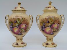 A pair of Aysnsley Orchard Gold pedestal covered vases signed Jones (22cm tall)