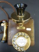 A reproduction brass wall mounted telephone in the style of a GPO 121