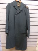 An East German trench coat with insignia to shoulders,