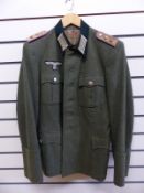 A WWII Nazi German officers tunic, the shoulder boards with pink border and two rank stars,
