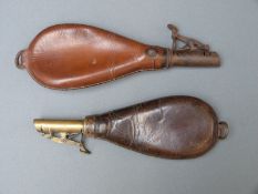 Two leather and brass shot flasks both with single suspension loops, largest 23cm long.