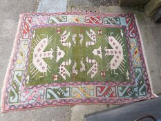 A green ground Turkoman rug with pink borders (190 x 140cm)