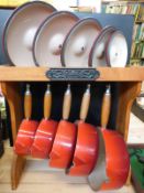 A set of five Le Creuset graduated saucepans on Le Creuset wooden stand