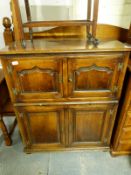 An oak drinks cabinet with twin cupboards and central brush slide (H110 x W91 x D40cm)