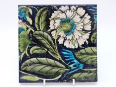 William de Morgan tile with floral decoration on a dark blue ground, maker's mark to back (15.
