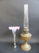 A brass oil lamp together with a glass bud vase with fluted vaseline-type decoration,