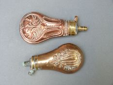 Two copper and brass pistol powder flasks both with embossed decoration, largest 11.5cm long.