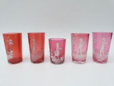 Five Mary Gregory cranberry glass drinking tumblers, all with enamel decoration,