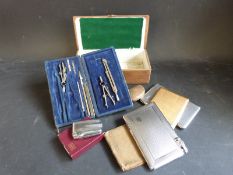 A cigar box containing cigarette cases and lighters, one being a combination example by Mosda,