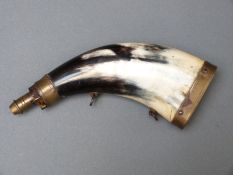 A horn and brass powder flask with two suspension rings, 20cm long.