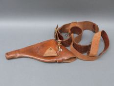 A brown leather pistol holster and belt with brass fittings and embossed stamp ' Fight the good