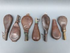 Seven leather shot flasks, one with embossed decoration of game birds, five with suspension loops,