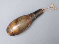 A turned all horn powder flask with screw off top and bottom, 13cm long.
