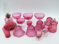 Eighteen cranberry glass lamps, shades, tazzas, plates etc,
