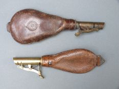 Two leather and brass shot flasks, one with embossed 'Warrented Solid Leather' stamp,