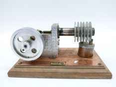 A freelance sterling hot air engine mounted on a wooden base with spirits burner