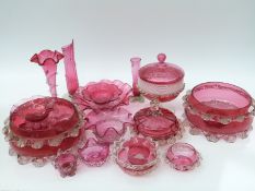 Nineteen cranberry glass bowls, vases, dishes etc all with applied decoration,