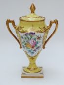 French porcelain urn with hand painted floral decoration and script to base (19cm tall)