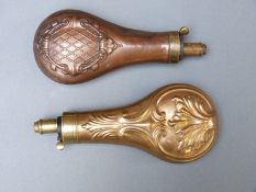 Two copper and brass powder flasks both with embossed decoration, largest 20cm long.