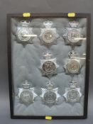 A display of eight police helmet badges including Hampshire and Isle of Wight,